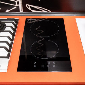 Электрическая варочная панель Maunfeld EVCE.292 Black в сочетании с оранжевой поверхностью